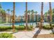 Scenic view of tennis courts with a green fence, lush landscaping, and a beautiful community building at 7189 S Durango Dr # 203, Las Vegas, NV 89113