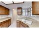 Corner kitchen sink with wood cabinets, laminate countertop, and window with natural light at 729 Scottsdale St, Henderson, NV 89002