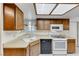 Kitchen featuring wood cabinets, white appliances, laminate countertop, and bright lighting at 729 Scottsdale St, Henderson, NV 89002