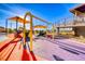 Colorful and shaded playground with swings and play structures in a park setting at 729 Scottsdale St, Henderson, NV 89002