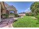 Manicured backyard with artificial turf, mature trees, and privacy, creating a serene outdoor space at 7418 Lawrence Powers Ct, Las Vegas, NV 89129
