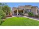 Spacious backyard with artificial turf, covered patio, and lush landscaping, ideal for entertaining at 7418 Lawrence Powers Ct, Las Vegas, NV 89129