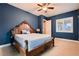 Elegant bedroom features blue walls, carpet flooring, natural light, and a decorative wooden bed frame at 7418 Lawrence Powers Ct, Las Vegas, NV 89129