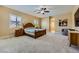 Spacious bedroom featuring neutral carpet, ceiling fan, and access to bathroom at 7418 Lawrence Powers Ct, Las Vegas, NV 89129