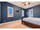 Large bedroom featuring multiple windows, carpet flooring, blue walls, and a ceiling fan at 7418 Lawrence Powers Ct, Las Vegas, NV 89129