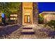 Close-up of the home's entrance featuring stone accents, a charming porch swing, and a well-maintained brick walkway at 7418 Lawrence Powers Ct, Las Vegas, NV 89129