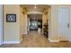 Hallway with arched entryways, neutral paint, tile flooring, and access to multiple rooms at 7418 Lawrence Powers Ct, Las Vegas, NV 89129