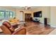 Cozy living room with wood floors, a large TV, and comfortable seating at 7418 Lawrence Powers Ct, Las Vegas, NV 89129