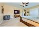 Bright main bedroom with a ceiling fan and neutral carpet provides space for a sitting area and a television at 7418 Lawrence Powers Ct, Las Vegas, NV 89129