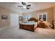This neutral main bedroom has carpet, a ceiling fan, and windows with plantation shutters for privacy at 7418 Lawrence Powers Ct, Las Vegas, NV 89129