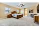 Main bedroom featuring carpeted flooring, plantation shutters, and a connecting bathroom at 7418 Lawrence Powers Ct, Las Vegas, NV 89129
