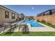 Backyard oasis boasts a sparkling pool, comfortable lounge chairs, and privacy landscaping at 7418 Lawrence Powers Ct, Las Vegas, NV 89129
