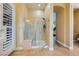Modern glass-enclosed shower with seating and neutral-colored stone tile surround at 7418 Lawrence Powers Ct, Las Vegas, NV 89129