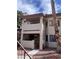 Two-story condo featuring stucco facade, small gated patio, and second-floor balcony in a well-maintained complex at 809 Rock Springs Dr # 202, Las Vegas, NV 89128