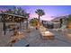 Evening view of backyard featuring a cozy gazebo, fire pit and hot tub at 8208 Fritzen Ave, Las Vegas, NV 89131