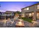 Relaxing backyard featuring a hot tub, fire pit, palm trees and outdoor seating under a colorful dusk sky at 8208 Fritzen Ave, Las Vegas, NV 89131