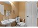 Stylish half bathroom featuring a modern sink, toilet, and a large, round mirror at 8208 Fritzen Ave, Las Vegas, NV 89131