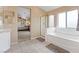 Bright bathroom features a tub, shower, and view into the bedroom that's carpeted and well lit at 8208 Fritzen Ave, Las Vegas, NV 89131