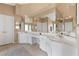 Bright bathroom boasts dual sinks, a large vanity area, ample lighting, and neutral tile flooring at 8208 Fritzen Ave, Las Vegas, NV 89131