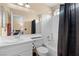 Bright bathroom with a shower-tub combo, white vanity, and a large mirror at 8208 Fritzen Ave, Las Vegas, NV 89131