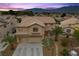 Two-story home featuring a spacious three-car garage, desert landscaping, and mature palm trees at 8208 Fritzen Ave, Las Vegas, NV 89131