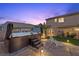 Backyard featuring a hot tub with water feature, seating, palm trees, garden, and outdoor lighting at 8208 Fritzen Ave, Las Vegas, NV 89131