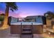 Wooden hot tub featuring water fountains, steps and handrails in a backyard setting at 8208 Fritzen Ave, Las Vegas, NV 89131