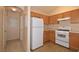 Simple yet efficient kitchen featuring wood cabinets, white appliances, and a convenient layout at 8842 Duncan Barrel Ave # 101, Las Vegas, NV 89178