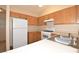 Functional kitchen featuring wood cabinetry and white appliances, with plenty of room for cooking at 8842 Duncan Barrel Ave # 101, Las Vegas, NV 89178