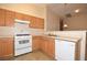 Bright kitchen featuring wood cabinets, white appliances, and tile flooring at 8842 Duncan Barrel Ave # 101, Las Vegas, NV 89178