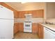 Well-lit kitchen boasts wood cabinets, white appliances, and ample counter space for meal preparation at 8842 Duncan Barrel Ave # 101, Las Vegas, NV 89178