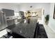 Open concept kitchen with stainless steel appliances and custom cabinets seamlessly flowing into the living area at 9028 Cypress Point Way, Las Vegas, NV 89117