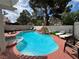 Inviting backyard pool with a spa, rock feature, and lounge chairs, perfect for relaxation and recreation at 9028 Cypress Point Way, Las Vegas, NV 89117