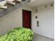 Outdoor entrance to condo unit with fire extinguisher and green shrubbery at 950 Seven Hills Dr # 114, Henderson, NV 89052