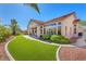 Beautiful backyard featuring lush, green turf, landscaping, and a covered patio at 9916 Netherton Dr, Las Vegas, NV 89134