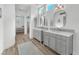 Hallway view of dual vanities in a bright bathroom at 9916 Netherton Dr, Las Vegas, NV 89134