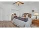 Bedroom with mirrored closet doors, ceiling fan and lamp on bedside table at 9916 Netherton Dr, Las Vegas, NV 89134