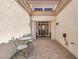 Charming courtyard entrance with a decorative patio set and covered walkway to the front door at 9916 Netherton Dr, Las Vegas, NV 89134