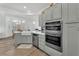 Bright kitchen featuring a stainless steel dishwasher, ovens, sink, and gray cabinetry at 9916 Netherton Dr, Las Vegas, NV 89134