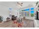 Bright living room featuring a ceiling fan, and a wall of windows with plantation shutters at 9916 Netherton Dr, Las Vegas, NV 89134