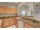 A kitchen with light wood cabinets, granite countertops, and stainless steel appliances at 10001 Peace Way # 2231, Las Vegas, NV 89147