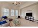 Sunlit living area features a sectional sofa, a modern TV stand and a ceiling fan at 10001 Peace Way # 2231, Las Vegas, NV 89147