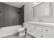 Updated bathroom featuring gray floors, shower/tub combo with modern gray horizontal tile and a white vanity at 1112 Observation Dr # 201, Las Vegas, NV 89128