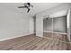 Bedroom featuring wood-look flooring, gray walls, ceiling fan and closet with mirrored sliding doors at 1112 Observation Dr # 201, Las Vegas, NV 89128