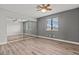 Bright bedroom featuring wood-look flooring, gray walls, ceiling fan and closet with mirrored sliding doors at 1112 Observation Dr # 201, Las Vegas, NV 89128