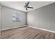 Neutral bedroom with light gray walls, wood-look floors, a window with blinds and a ceiling fan at 1112 Observation Dr # 201, Las Vegas, NV 89128