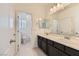 Bright bathroom featuring a double vanity, large mirror, and access to a shower/tub, offering convenience at 12546 Mosticone Way, Las Vegas, NV 89141