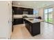 Modern kitchen with dark cabinetry, stainless steel appliances, and a granite island at 12546 Mosticone Way, Las Vegas, NV 89141