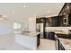 Modern kitchen featuring a central island with granite countertops and stainless steel appliances at 12546 Mosticone Way, Las Vegas, NV 89141