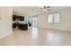 Open-concept living room and kitchen featuring tile floors, a ceiling fan, and plenty of natural light at 12546 Mosticone Way, Las Vegas, NV 89141
